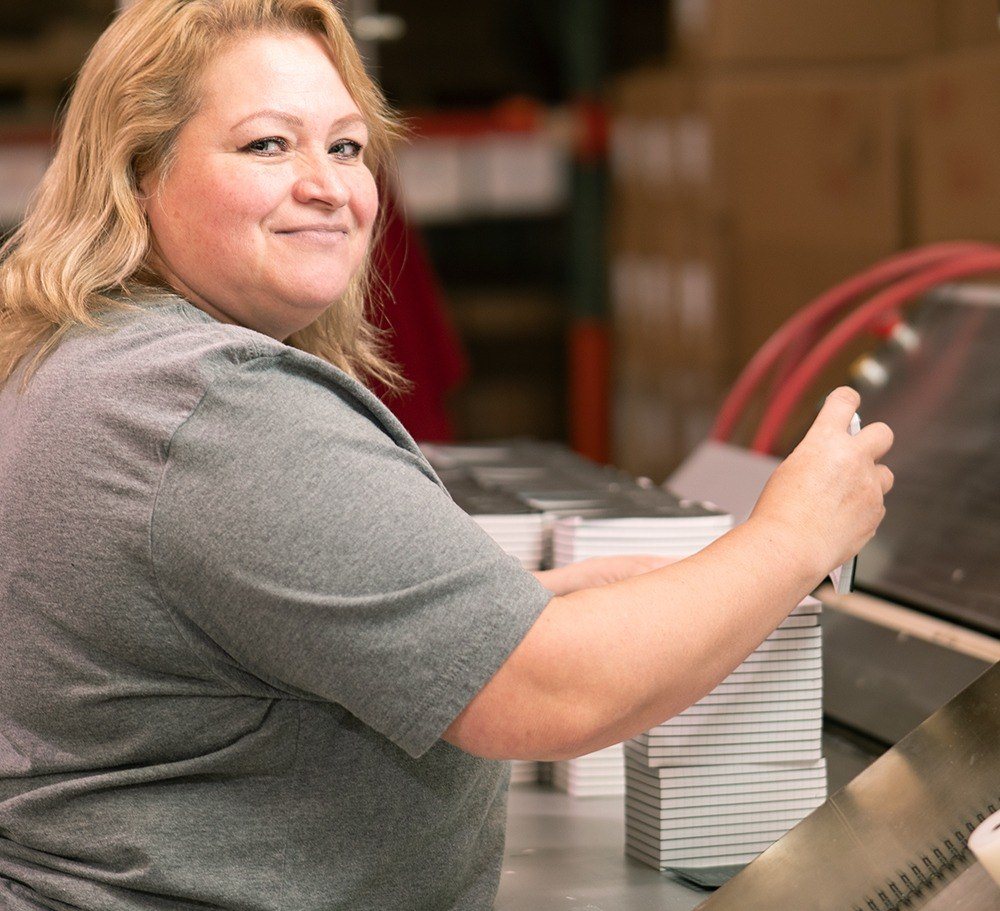 Wire-o Machine operator looking at camera.