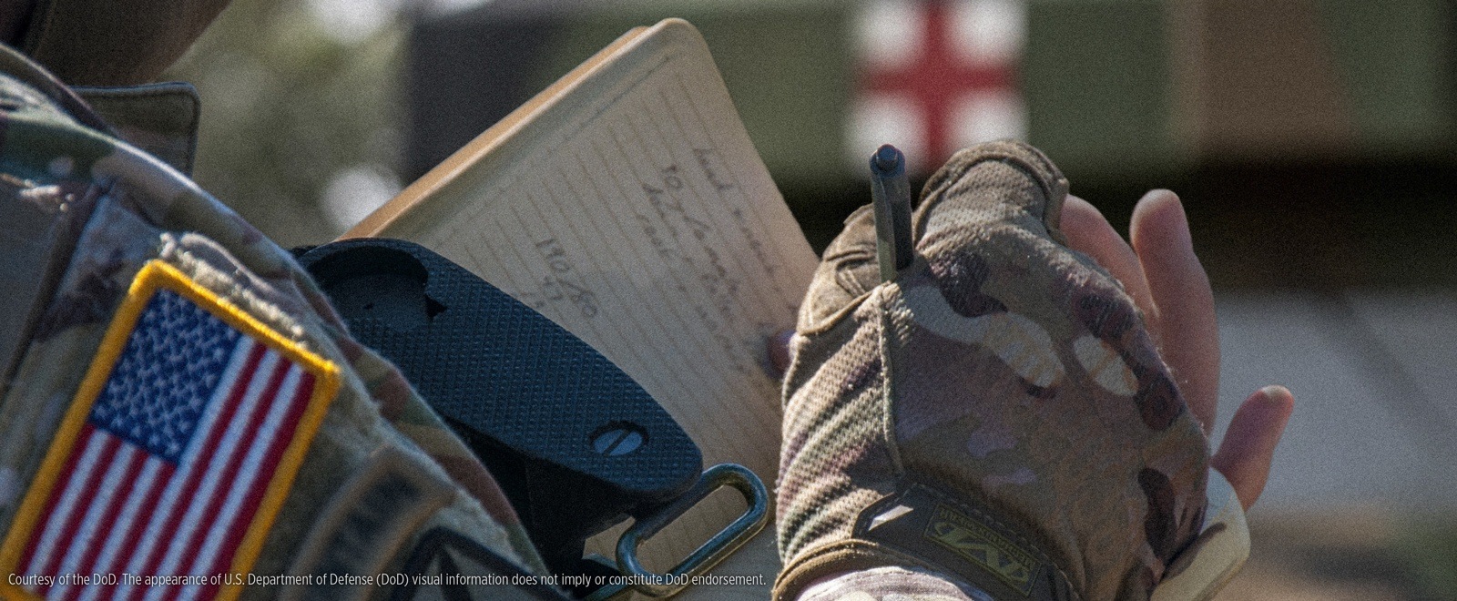 Medic writing in Medic Field Book with all weather pen.