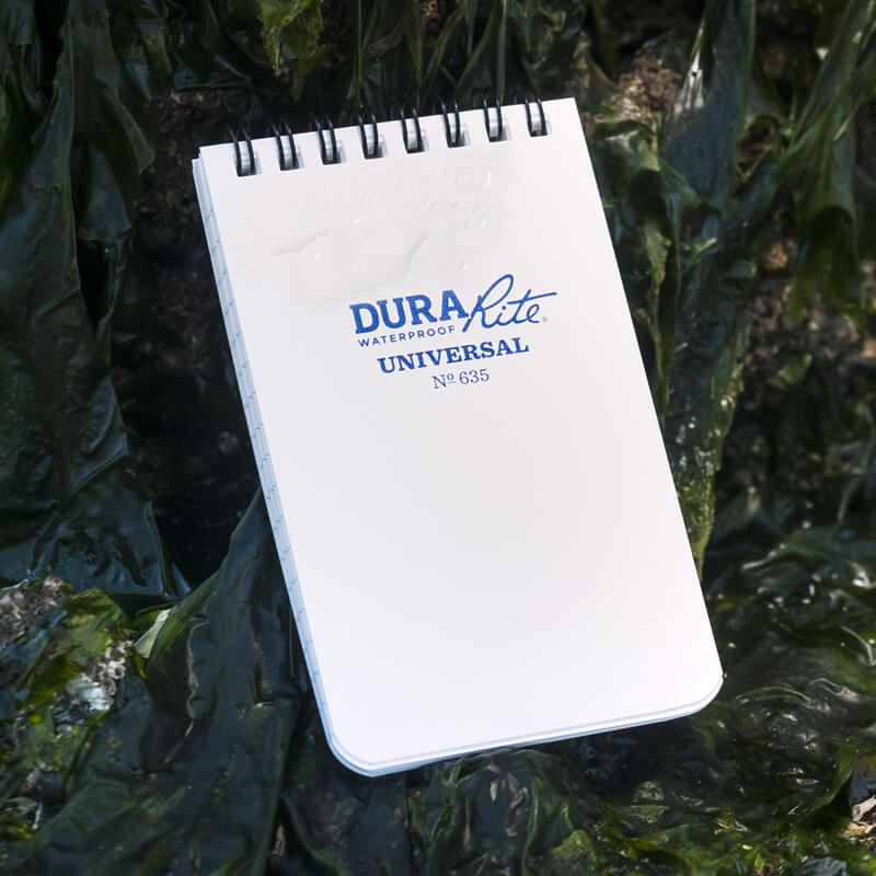 DuraRite top spiral notebook sitting in the water.
