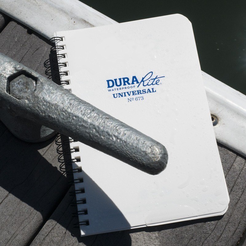 DuraRite top spiral notebook sitting in the water.