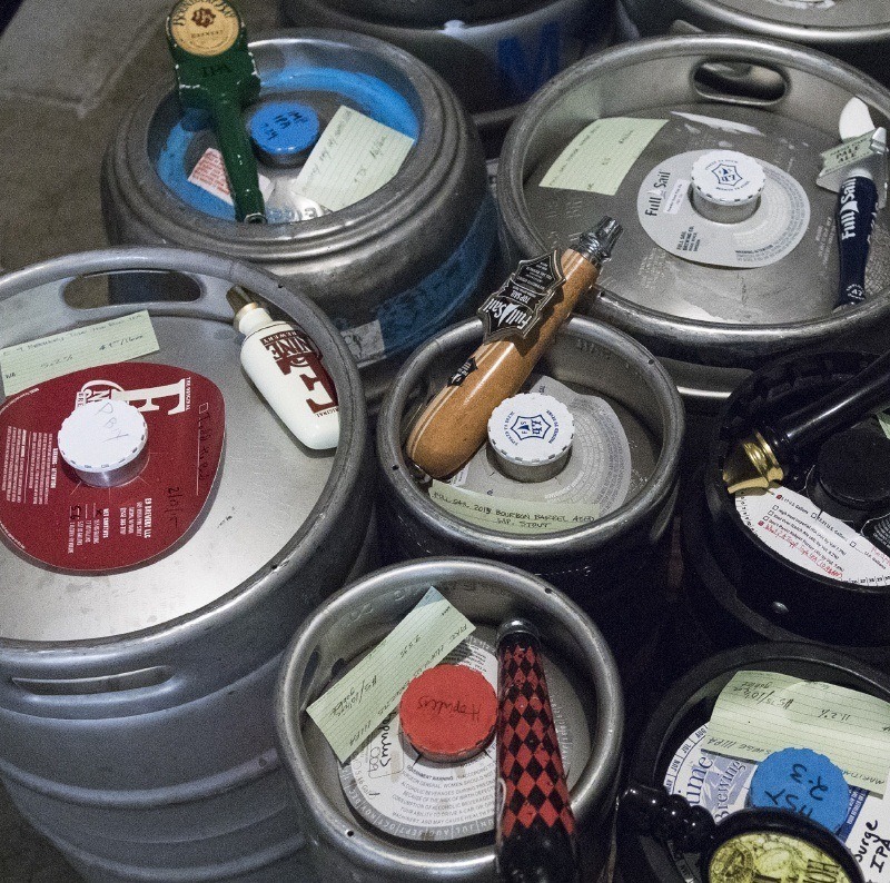 Index cards and taps on top of kegs in a cooler