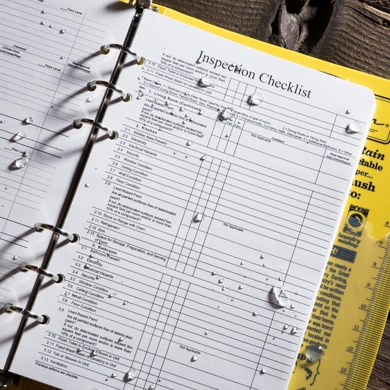 Ring binder open with wet form printed on all-weather loose leaf printer paper