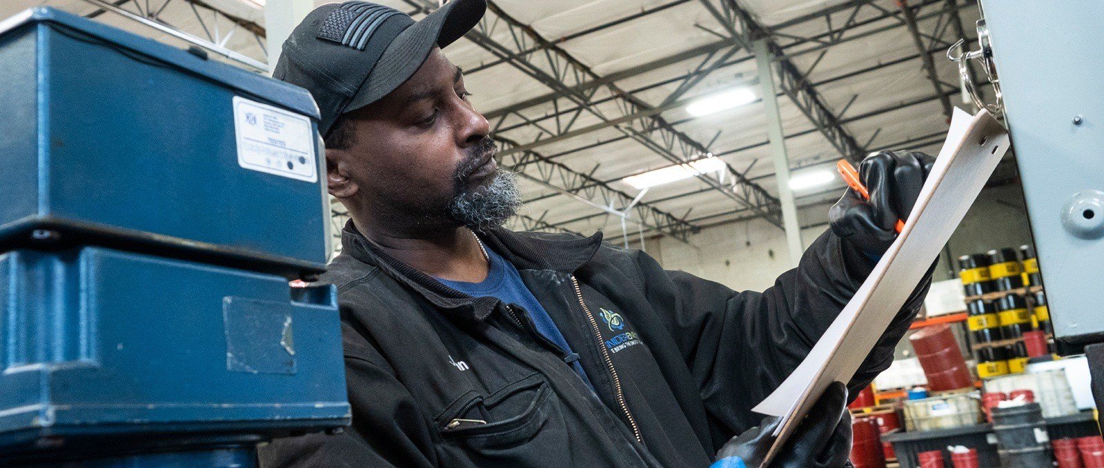 Person in a fuel transport warehouse, writing on weatherproof printer paper, using an all-weather pen.