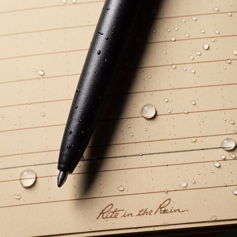 All weather pen laying on wet paper with ink written through water.