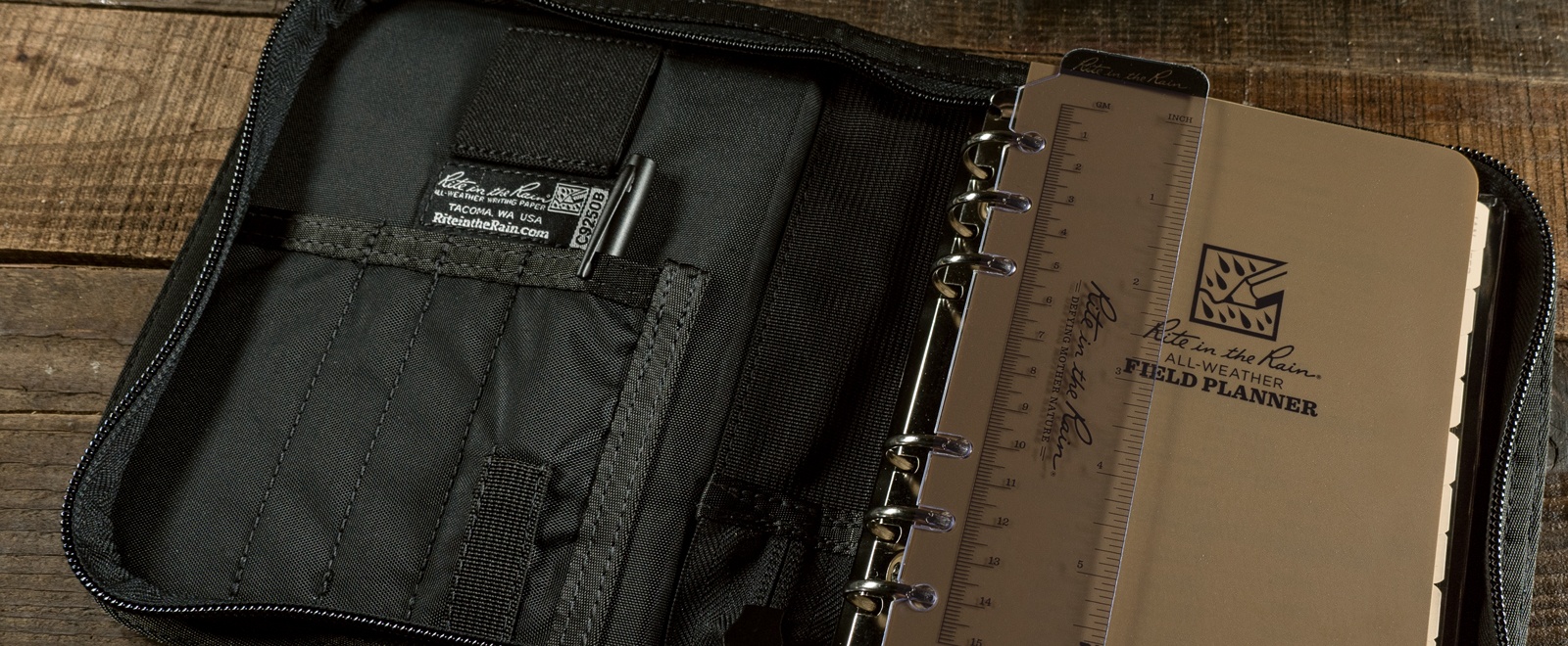 Open planner kit containing all-weather pen, writing guard, ruler, and rings.